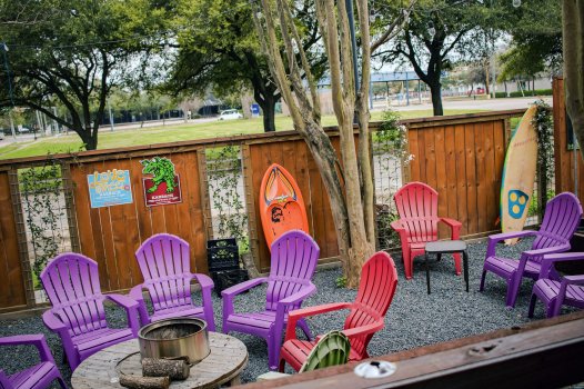 A picture of Java Lava's outdoor area with patio furniture surrounding a wood and metal fire pit